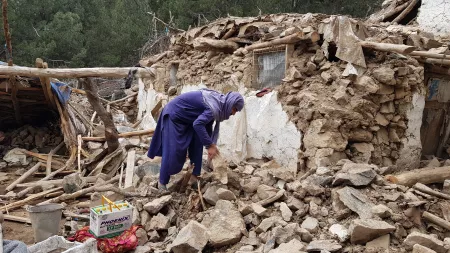 Women searching under the rubble, destroyed house