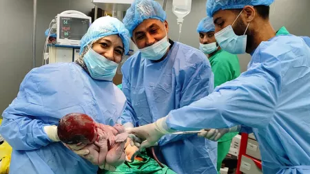 Doctors in operating room holding newborn baby.