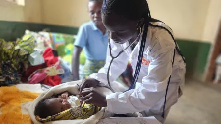 A midwife in the Democratic Republic of Congo performs a routine check up on a newborn baby