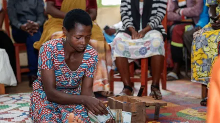 A member of a VSLA counts money