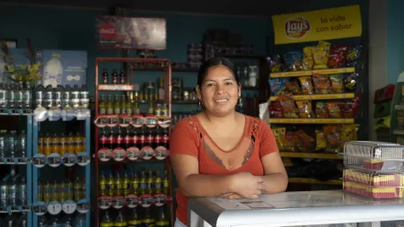 Lizbeth stands outside her bodega in Peru, where her growing business supports her family and future.