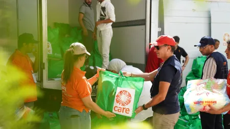 CARE staff unload trucks carrying food supplies and dignity kits in Outghal village, Morocco.