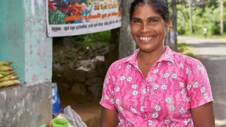 Woman wearing flower pink shirt smiling at the camera.