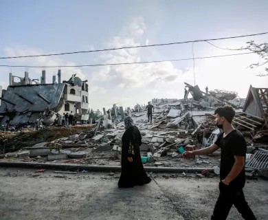 Palestinian woman inspects her destroyed house after an Israeli air strike in Beit Lahia northern Gaza strip