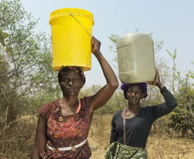 Two Women, head porters, yellow bucket