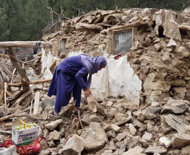 Women searching under the rubble, destroyed house