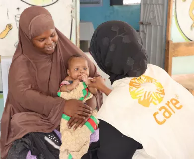 A CARE Somalia health worker checks on a child at a health facility. 